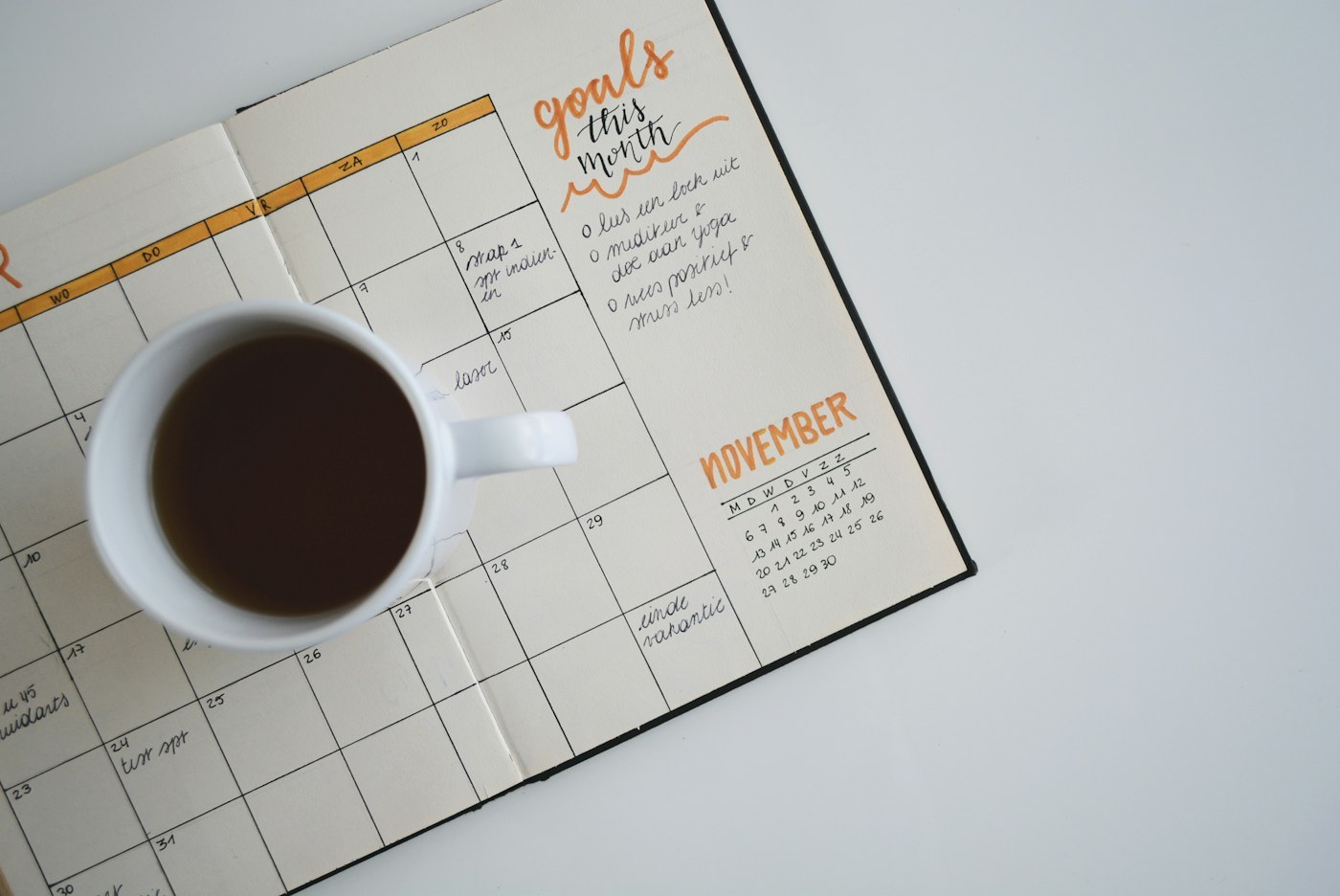 A planner and a cup of coffee on a desk